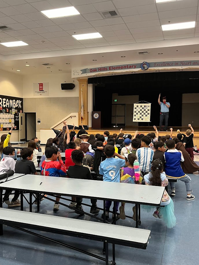 Students raising their hands at a school chess assembly